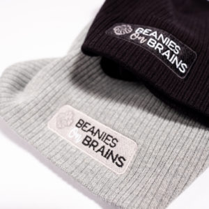 Gray and black beanies with Beanie On Brains logo